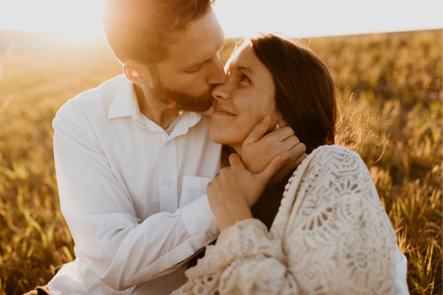 Maternity Family Photos in Calgary with mother and father dressed up for their pregnancy photoshoot with white flowy dress and baby boy in mothers belly near the mountains in Calgary Alberta during a beautiful sunset, maternity lifestyle photos in Calgary, casual lifestyle maternity photoshoot, baby photos